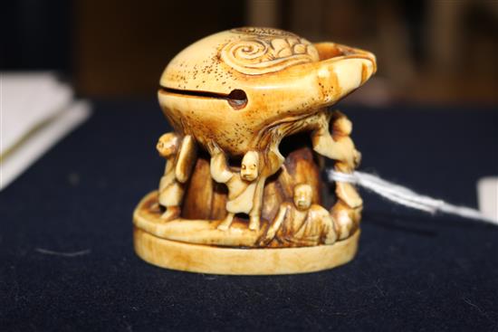 A carved ivory of figures under a crab